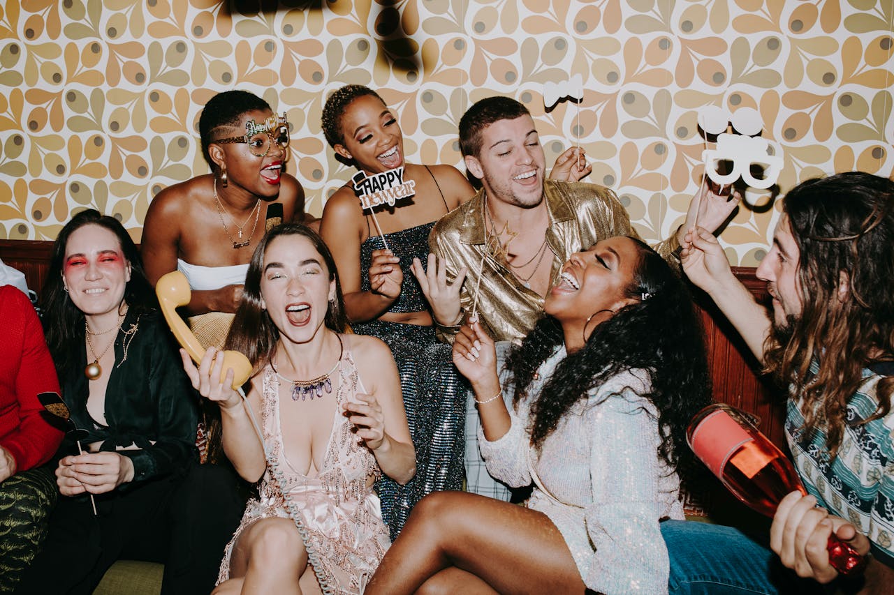 about-us A diverse group of friends joyfully celebrating New Year's Eve indoors, capturing festive fun.